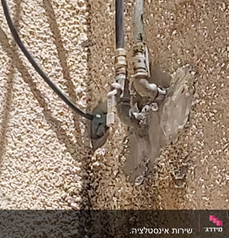 צינורות מחוברים לקיר עם מחברים מתכתיים